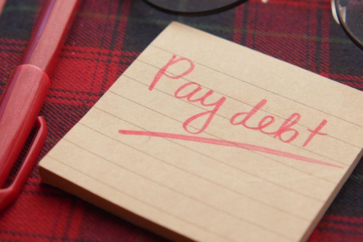 A picture of a note saying "Pay debt".