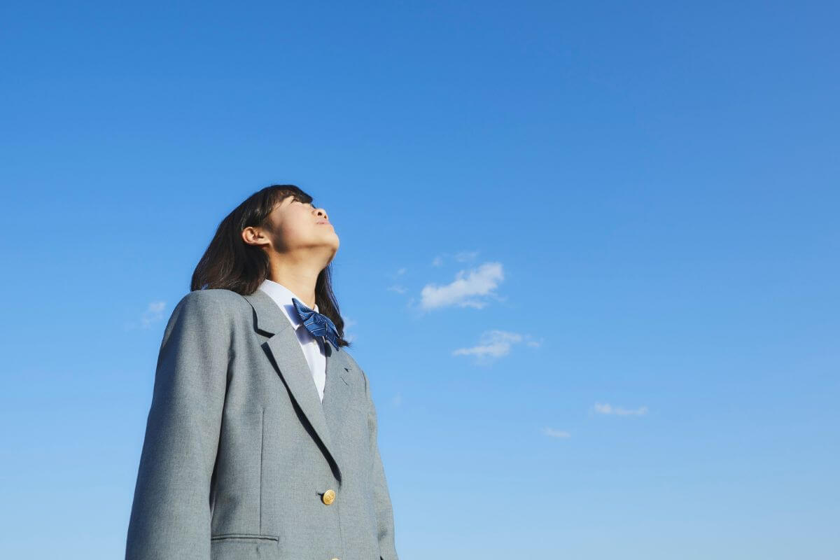A picture of someone young looking at the sky.