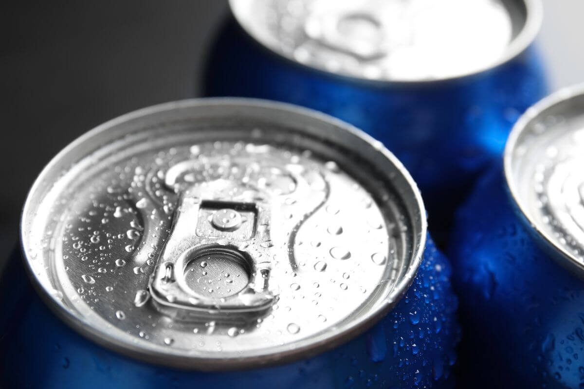 A picture of soda cans with a blue can.