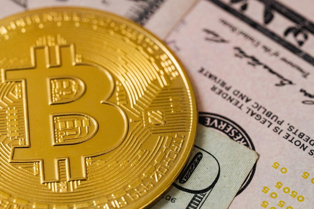 A picture of a bitcoin token and cash.