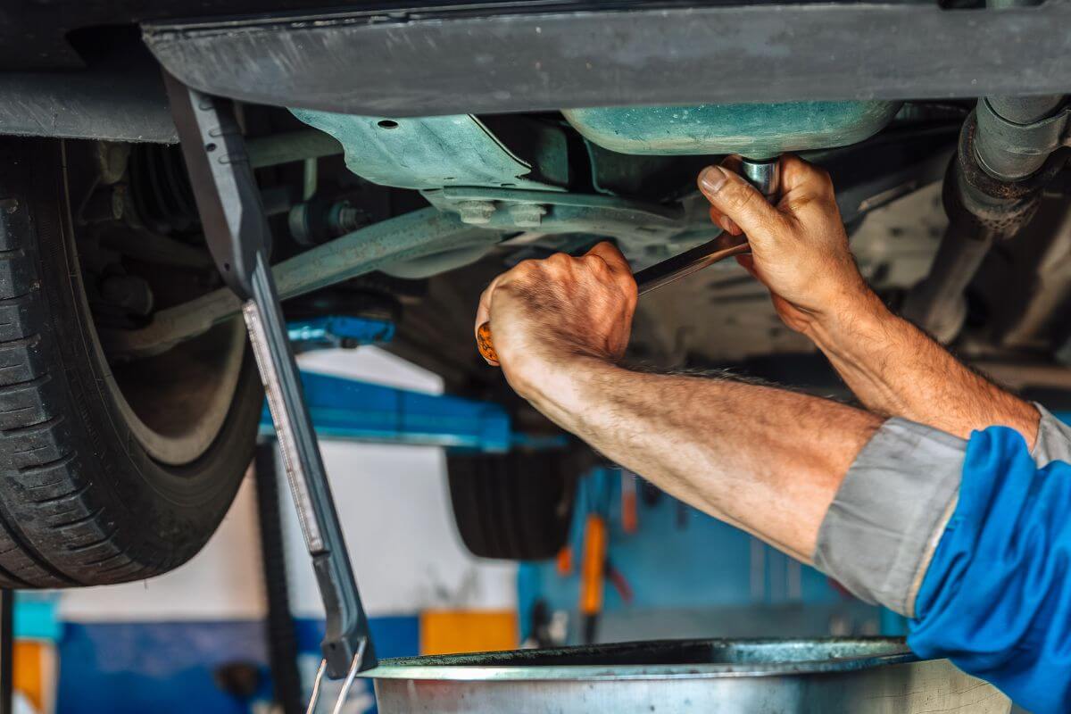 A picture of someone repairing a car.