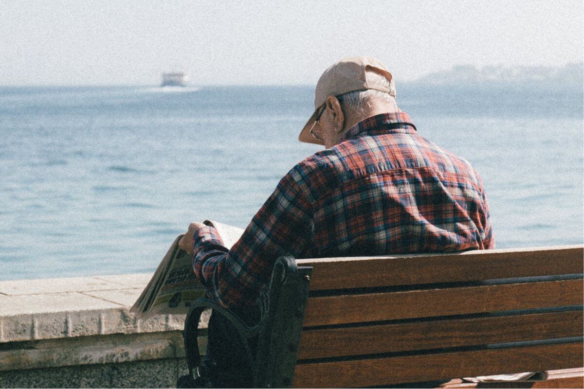 A picture of a retiree reading a newspaper.