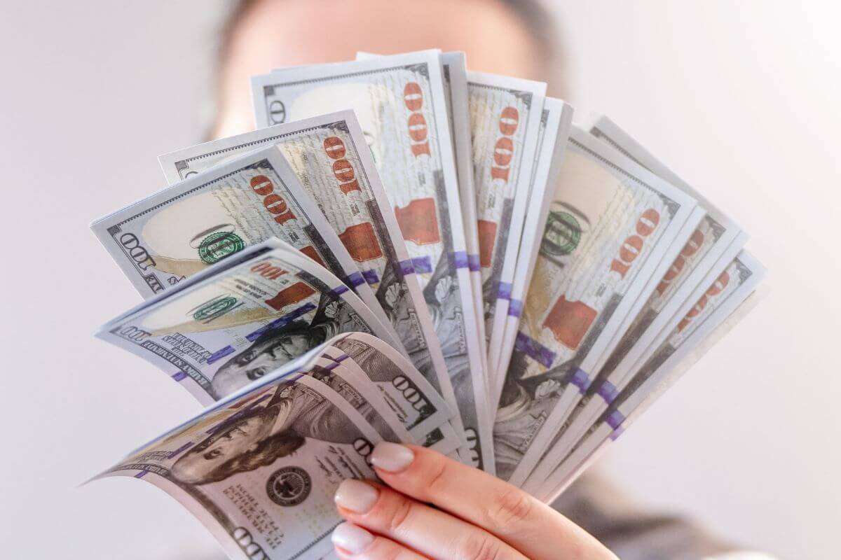 A picture of someone with hundreds of dollars.