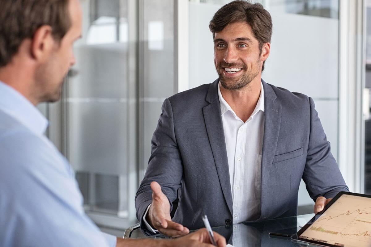 An image shows a financial advisor and his client talking.