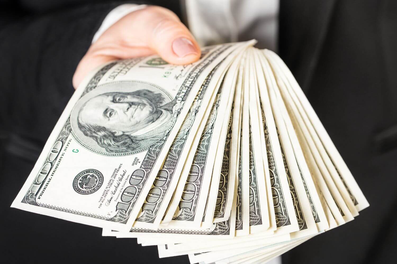 An image of a woman's hand showing off money.