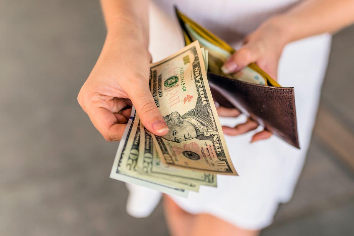An image shows a woman showing money.