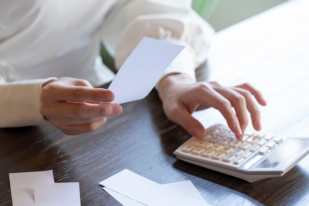 An image of a woman calculating her expenses.