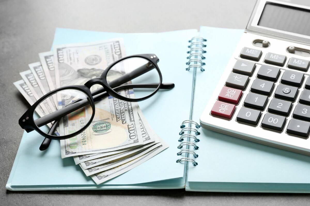 An image shows money and a notebook.