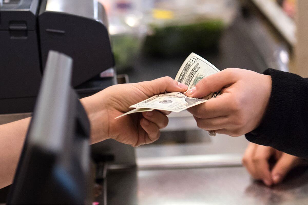 A picture shows a woman paying with cash.