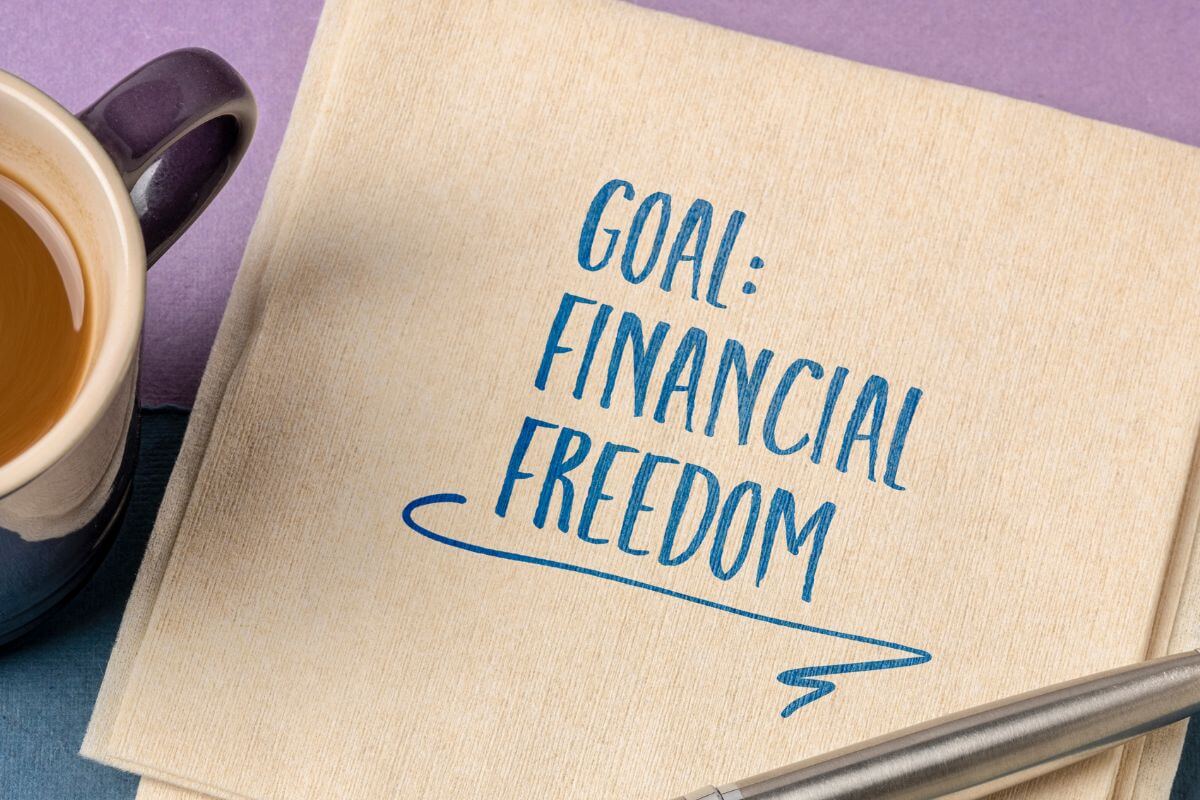 A picture shows a paper with a financial freedom goal written on it.