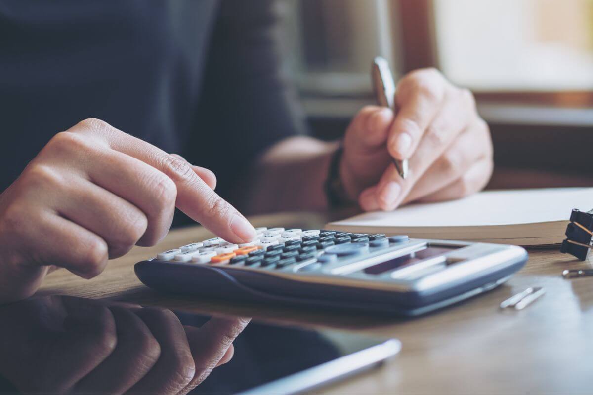 An image shows a woman's hand calculating.