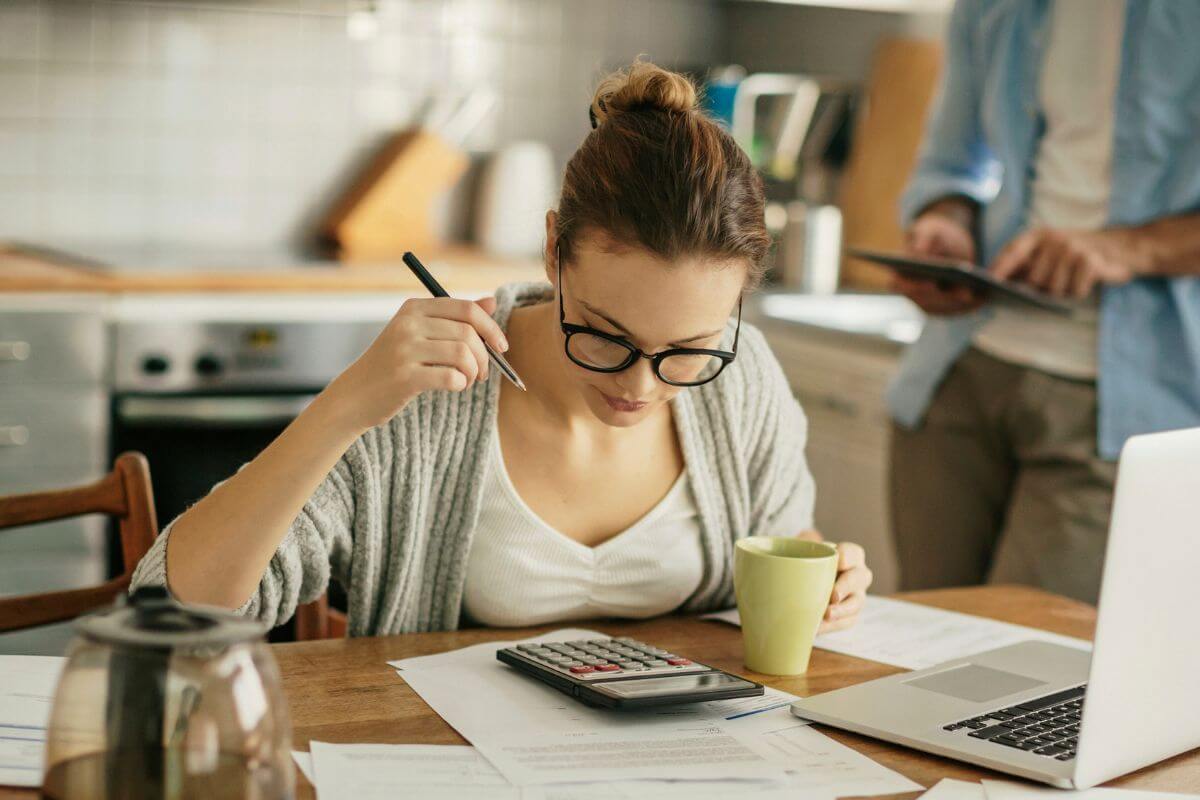 An image shows a woman budgeting.