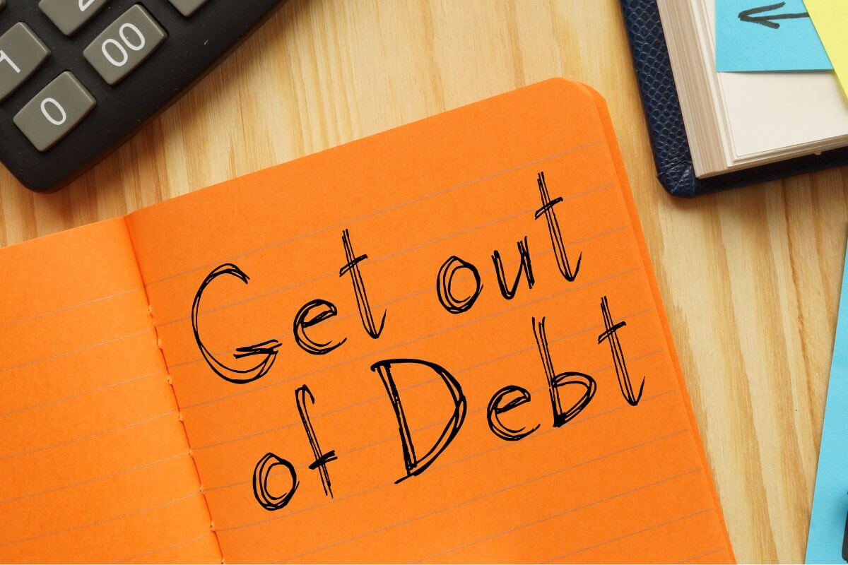 A picture shows a notebook with a get out of debt wording.