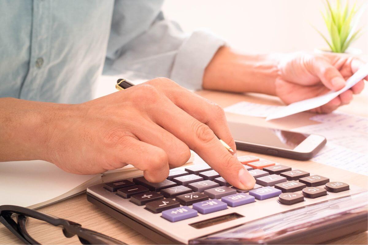 A picture shows a man calculating his expenses.