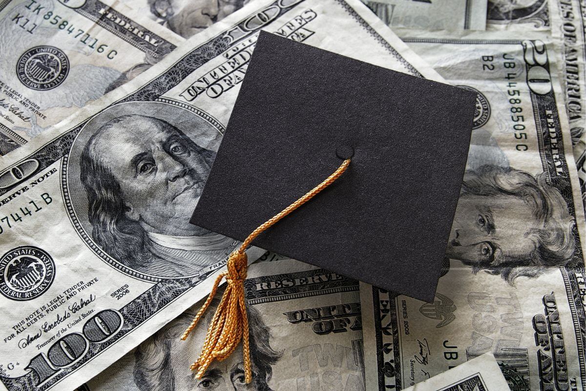 A picture shows a graduation cap and money.