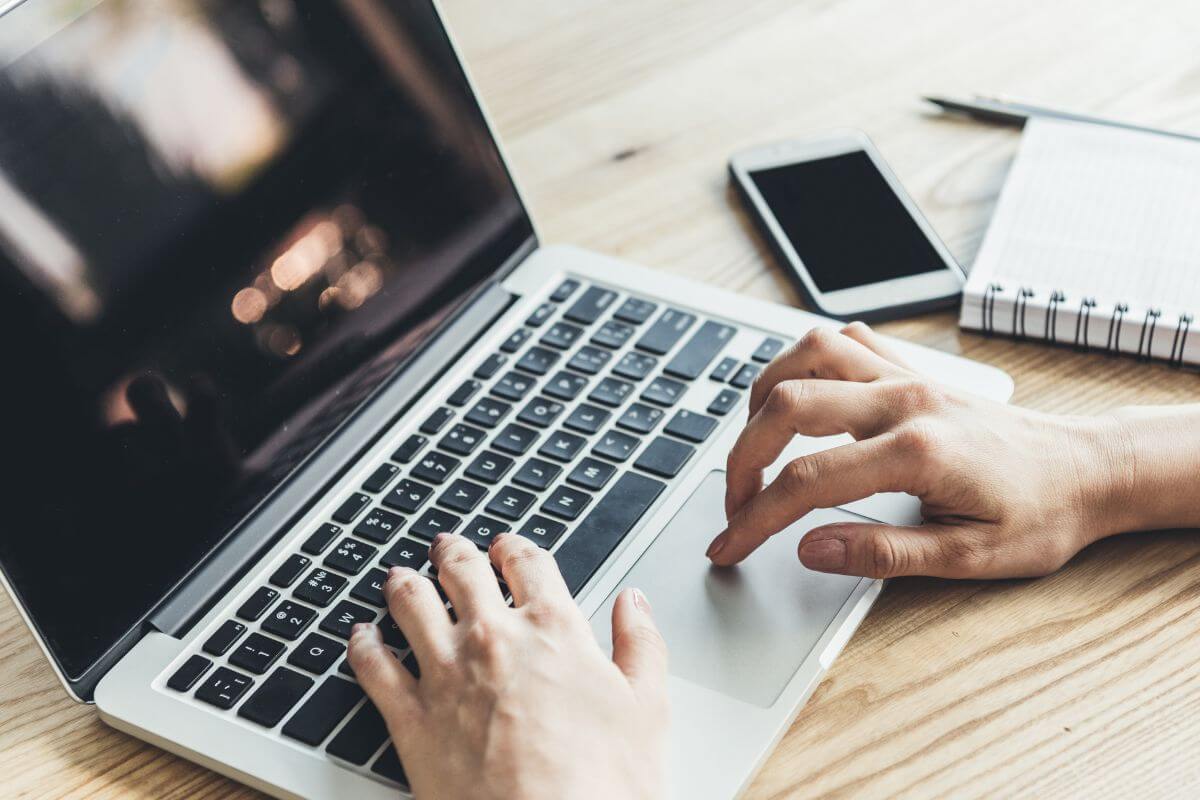 A picture shows a woman's hand using a laptop.