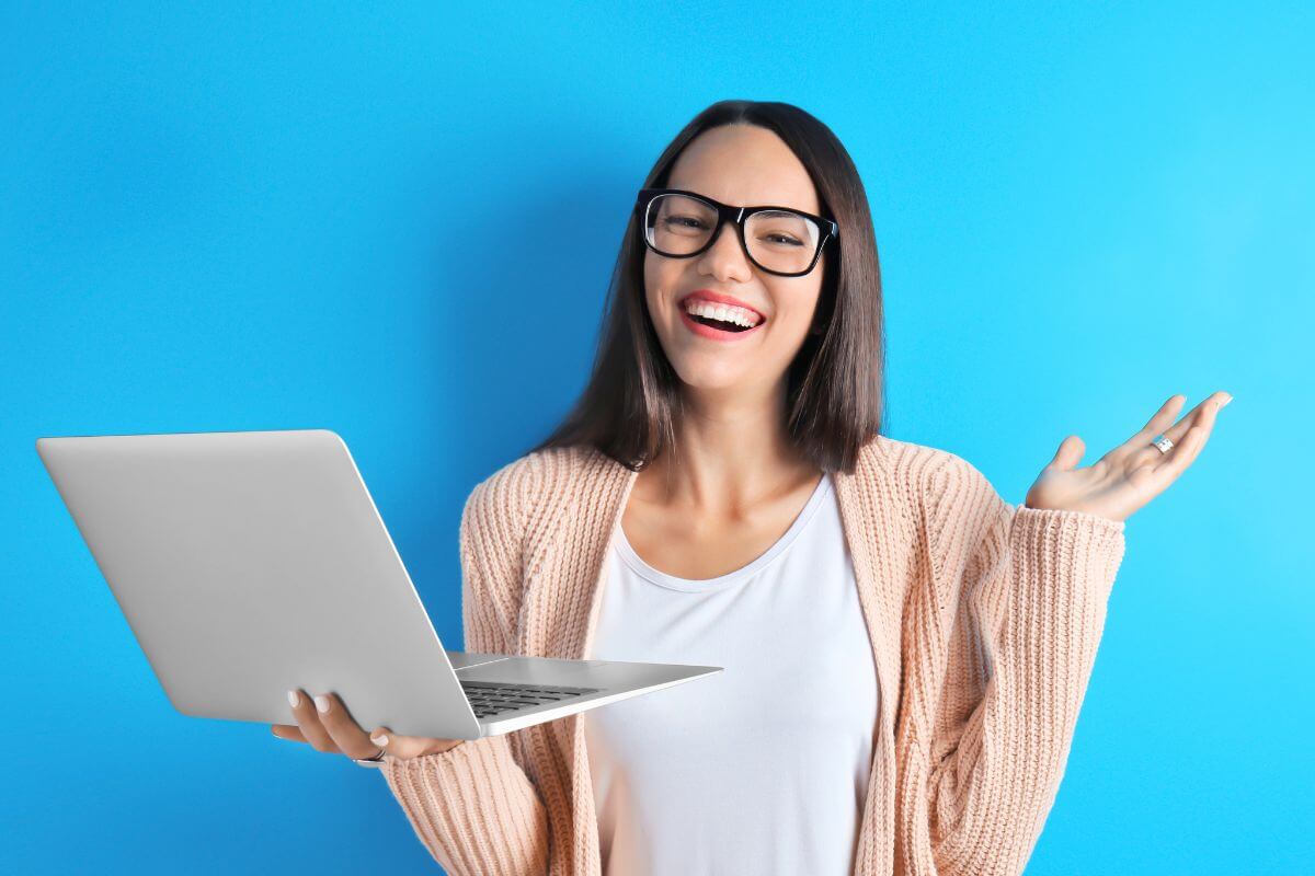 An image of a happy lady holding a laptop.