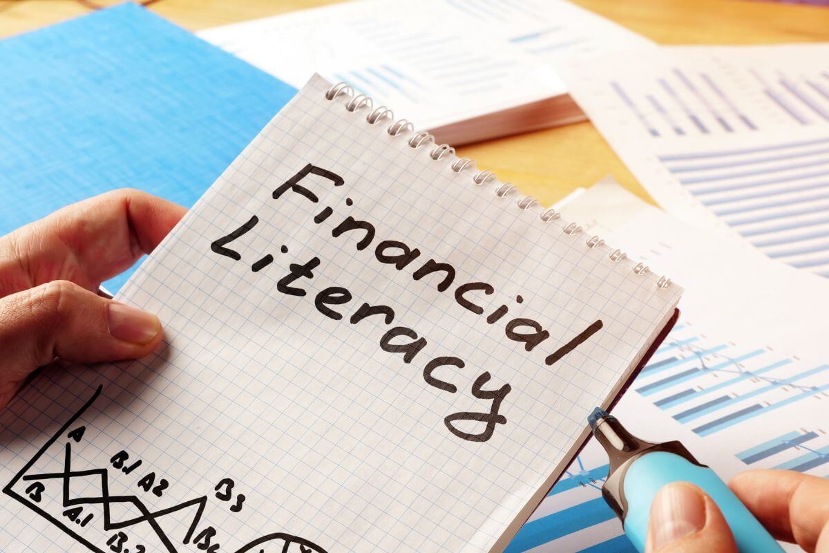 A picture shows a notebook with financial literacy wording.