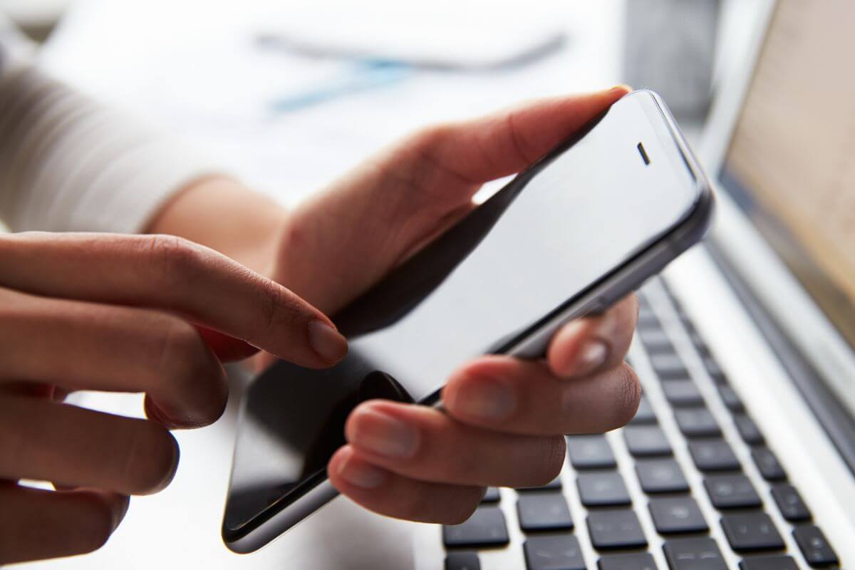 A picture shows a woman's hand using a phone.