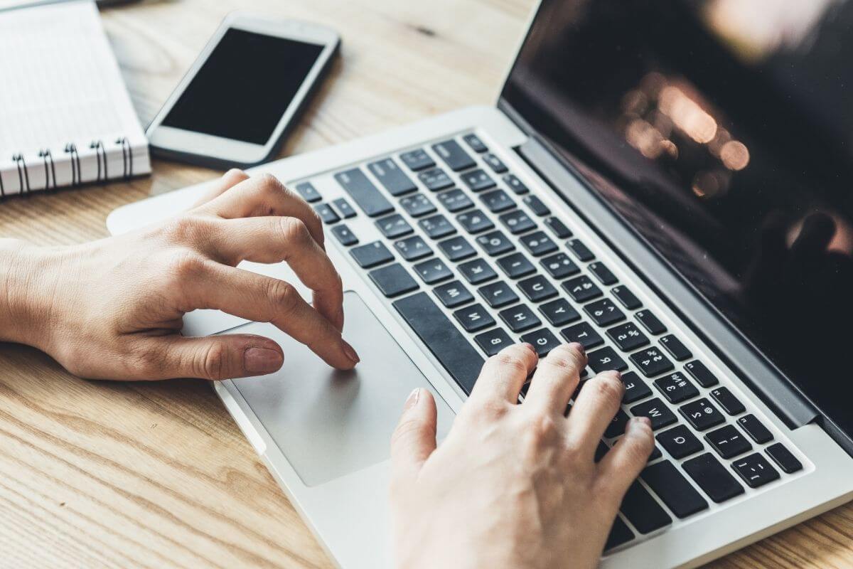 A picture shows a woman's hand working on a laptop.