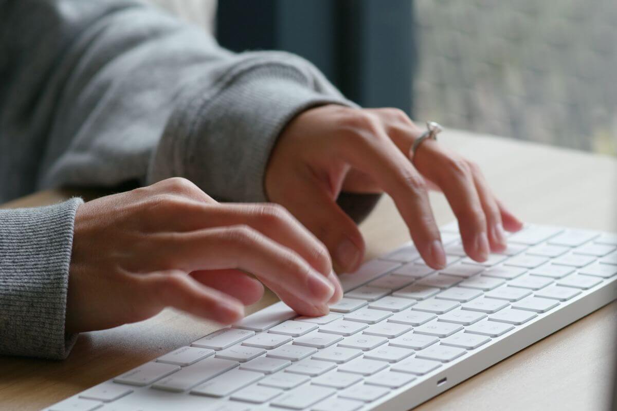 A picture shows a woman's hand typing on a keyboard.