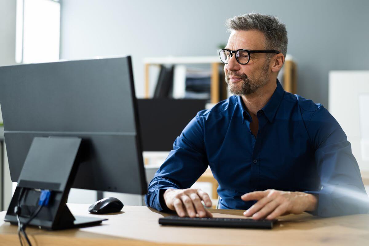 An image shows a man using a computer.