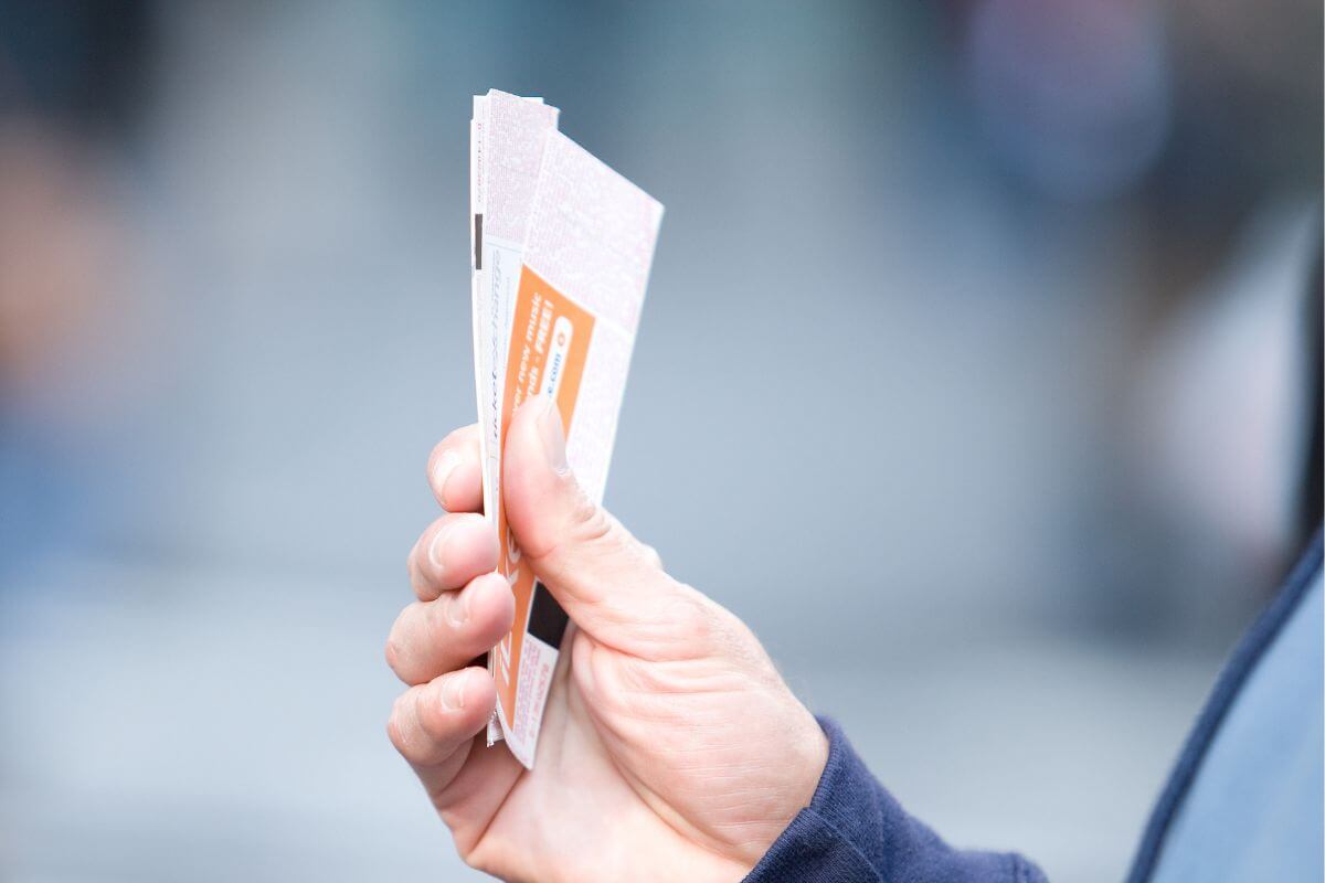 A picture shows a man's hand holding a ticket.
