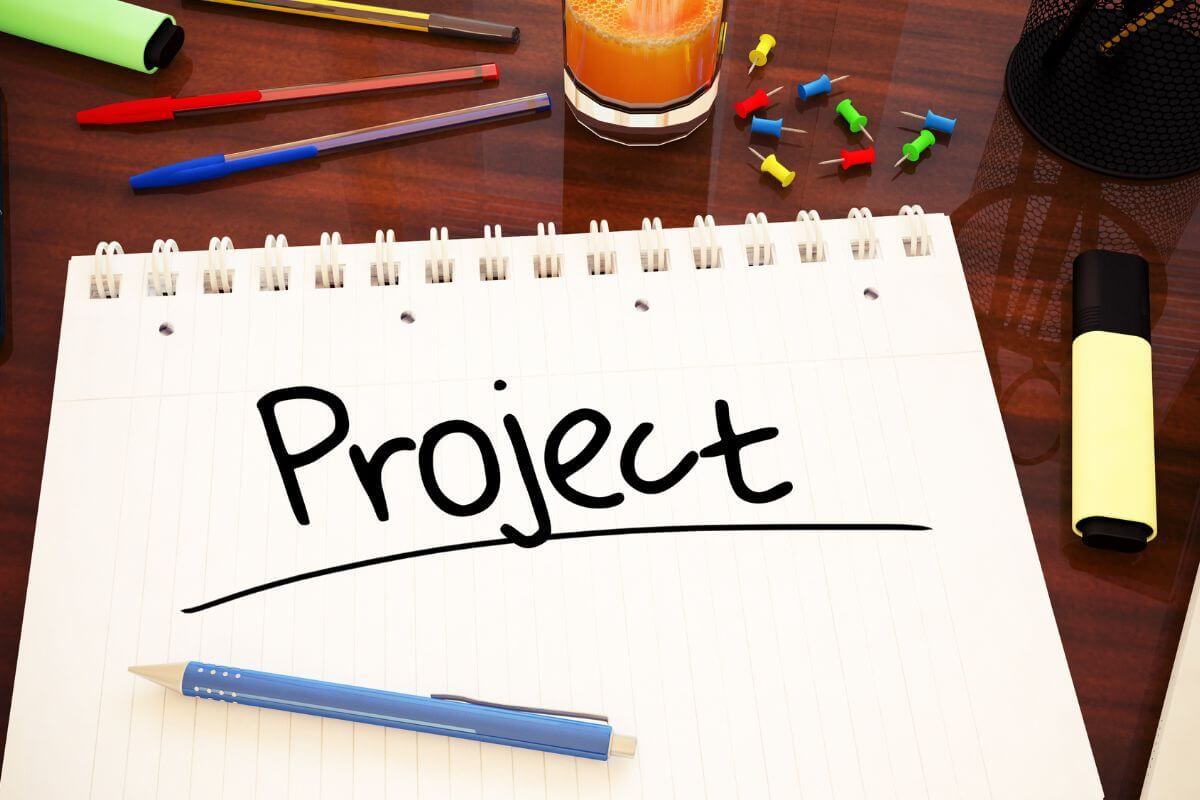 A picture shows a notebook with project wording.