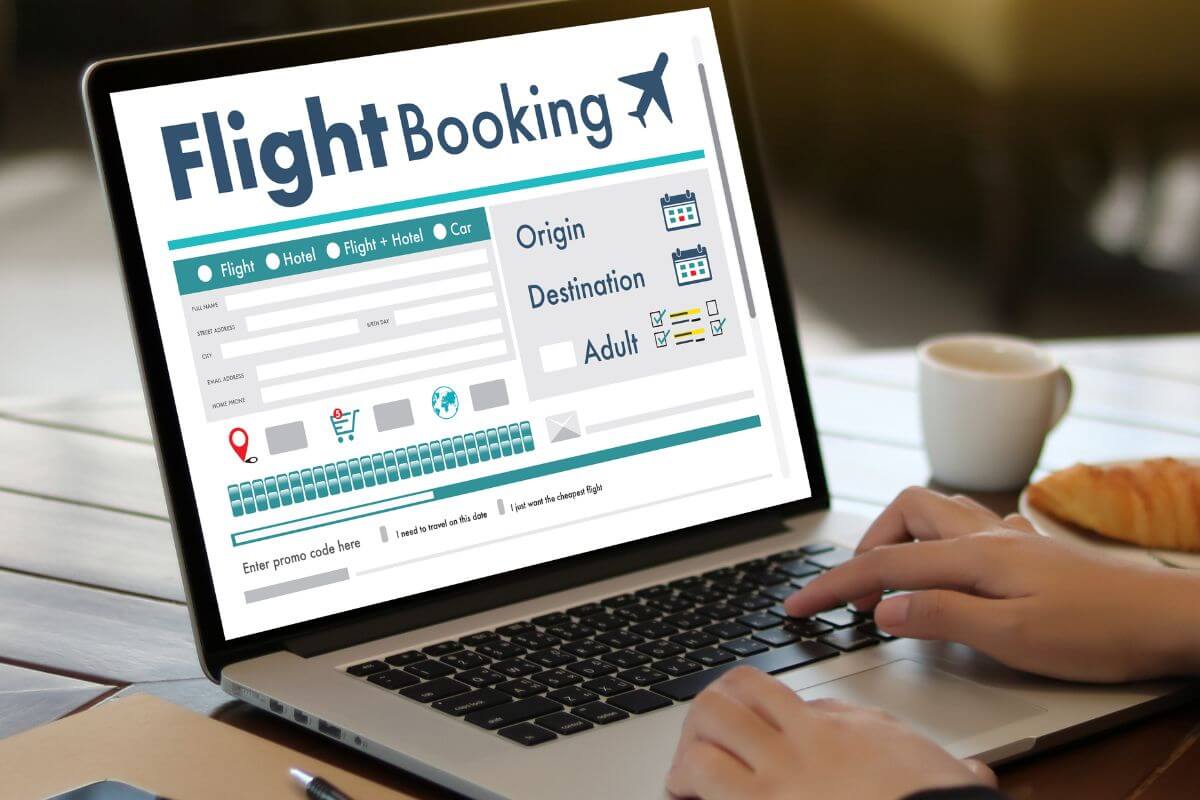 A picture shows a woman's hand booking a flight online.