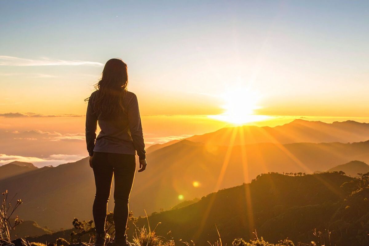 An image of a woman watching the sunrise.