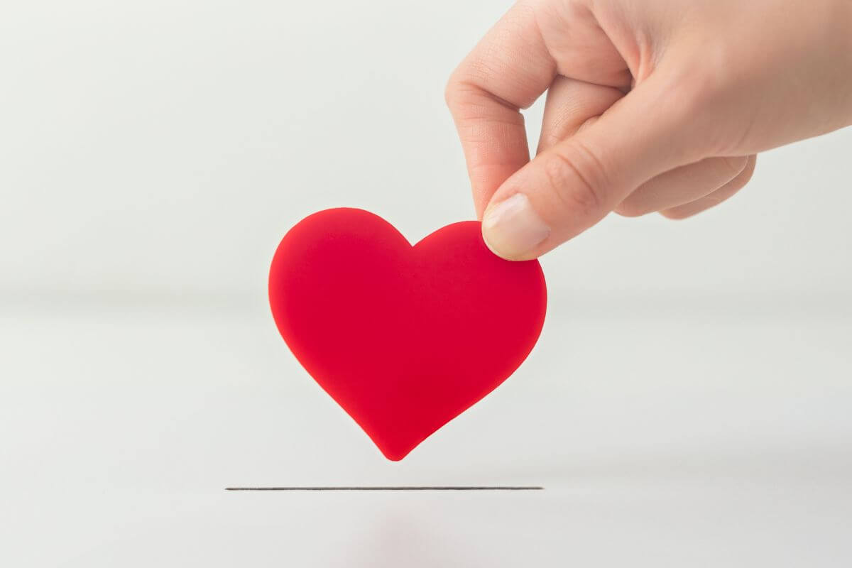 A picture shows a woman's hand holding a heart shape.