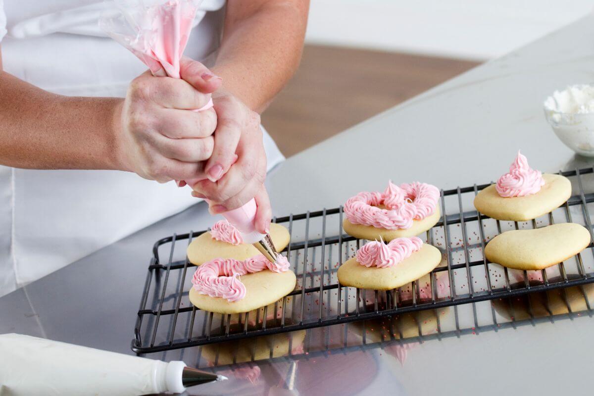 A picture shows a woman baking and decorating cookies.
