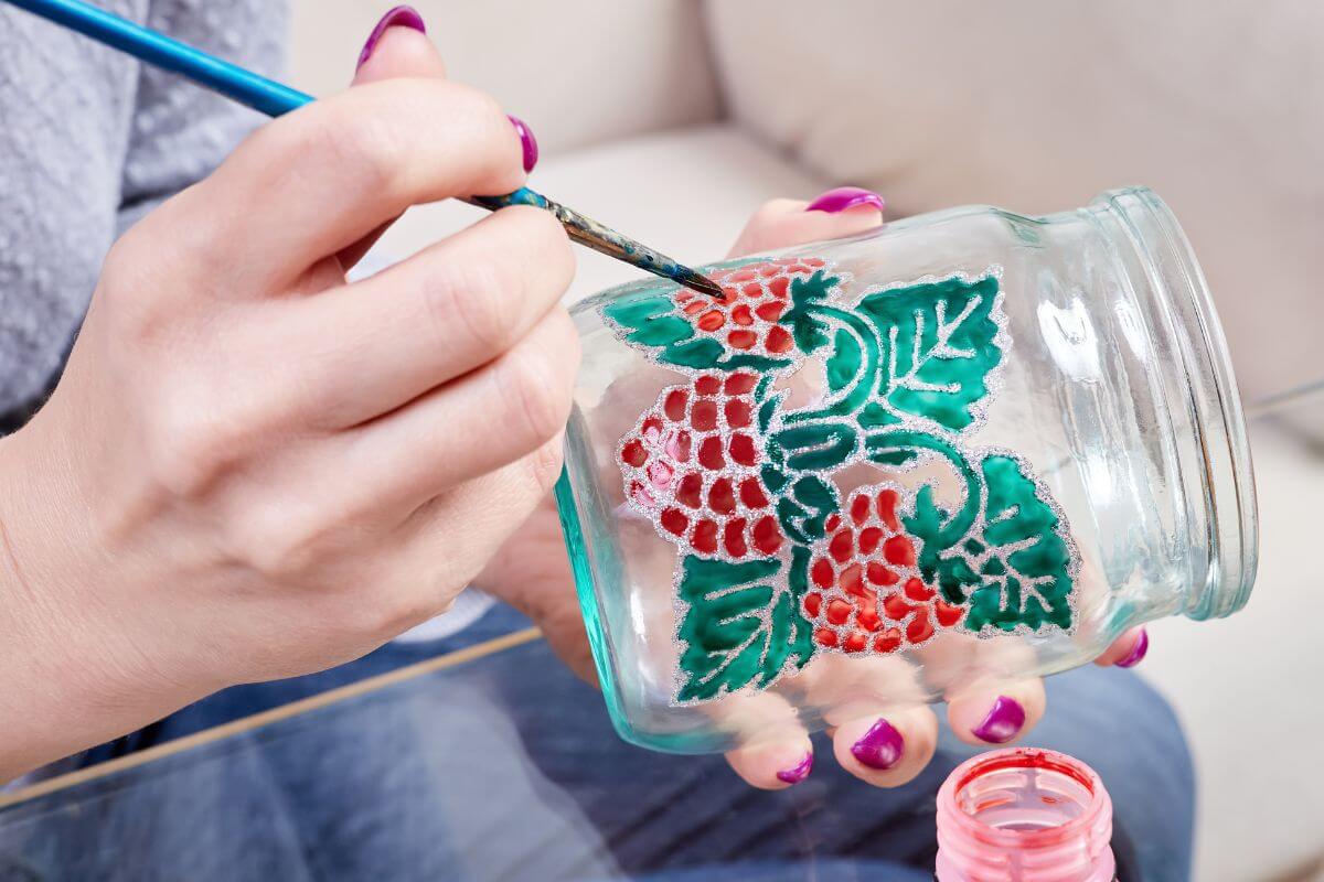 A picture shows a woman painting a jar.