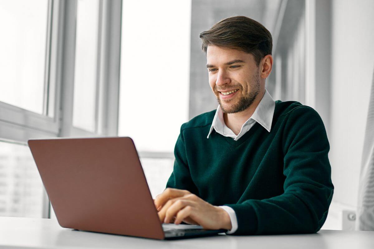 An image of a man working on a laptop.