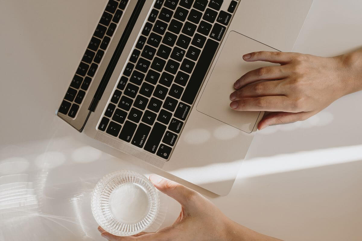 A picture shows a woman's hand using a laptop.