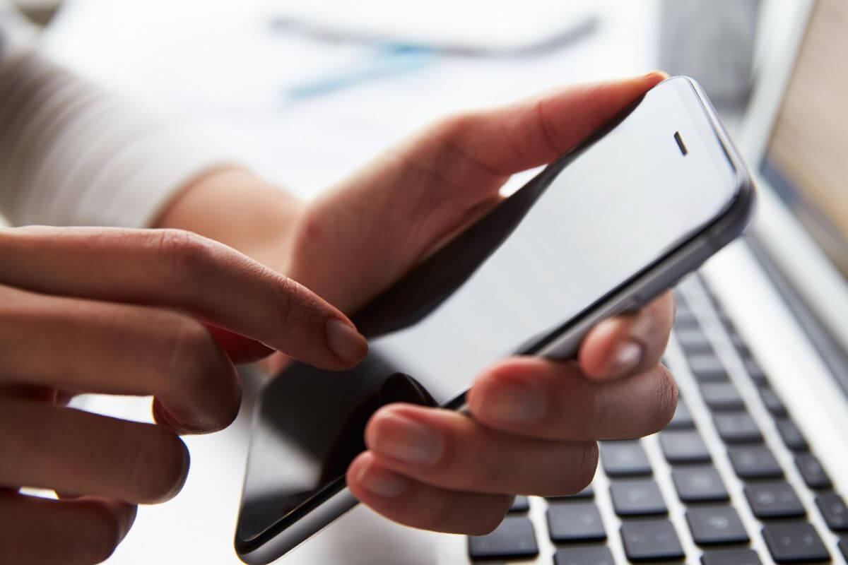 A picture shows a woman's hand using a phone.