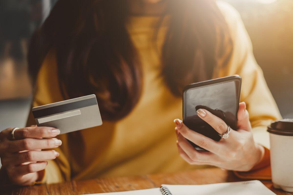 A picture of someone with their phone and credit card.