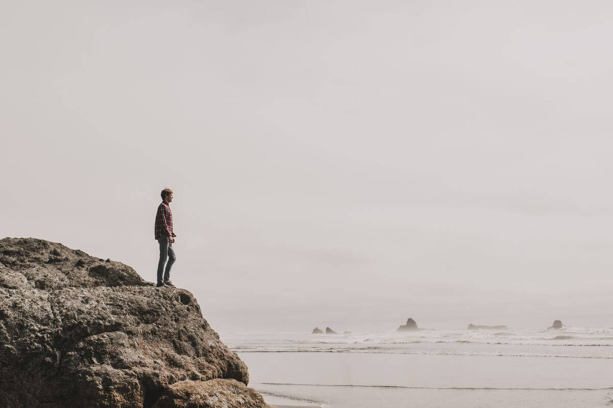 A picture of a man standing on top of a high place.