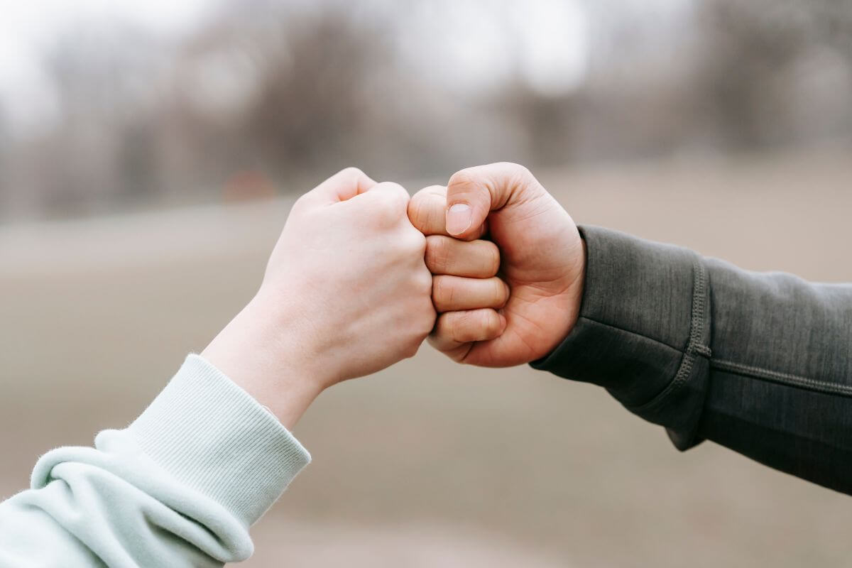 A picture of friends fistbumping.