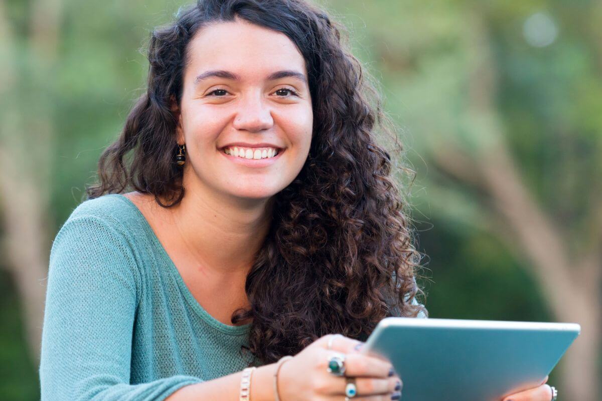 An image shows a woman holding a tablet device.