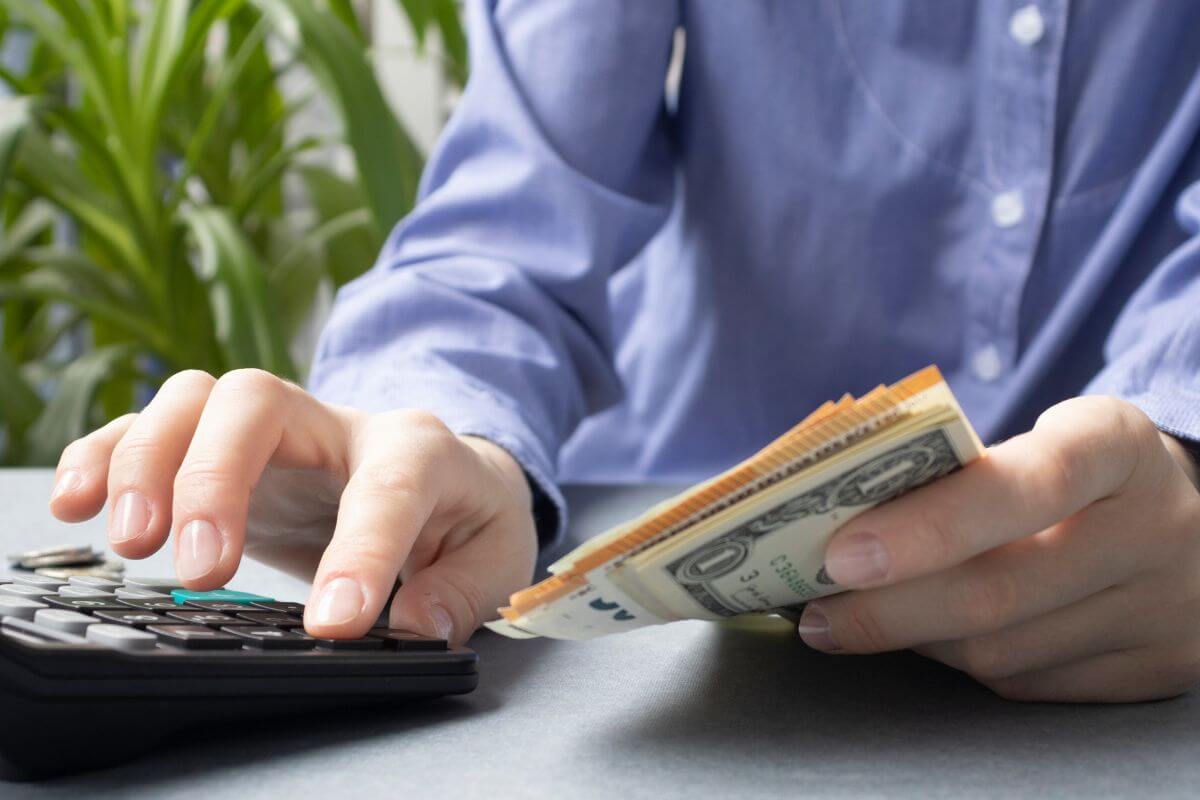 An image shows a man calculating money.