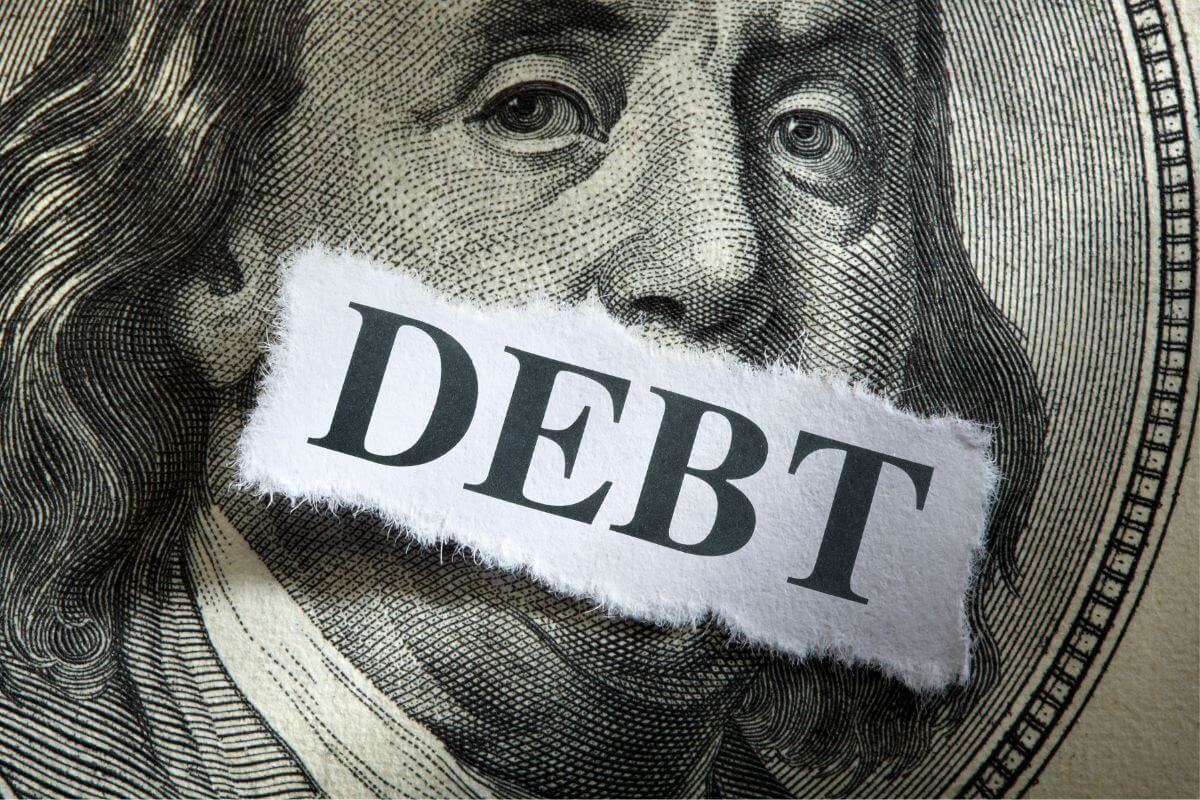 A picture shows a paper with debt wording.