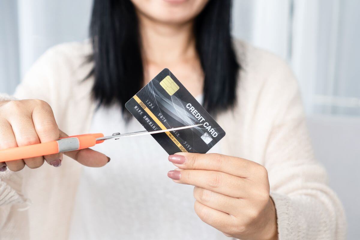 A picture of someone cutting their credit card.