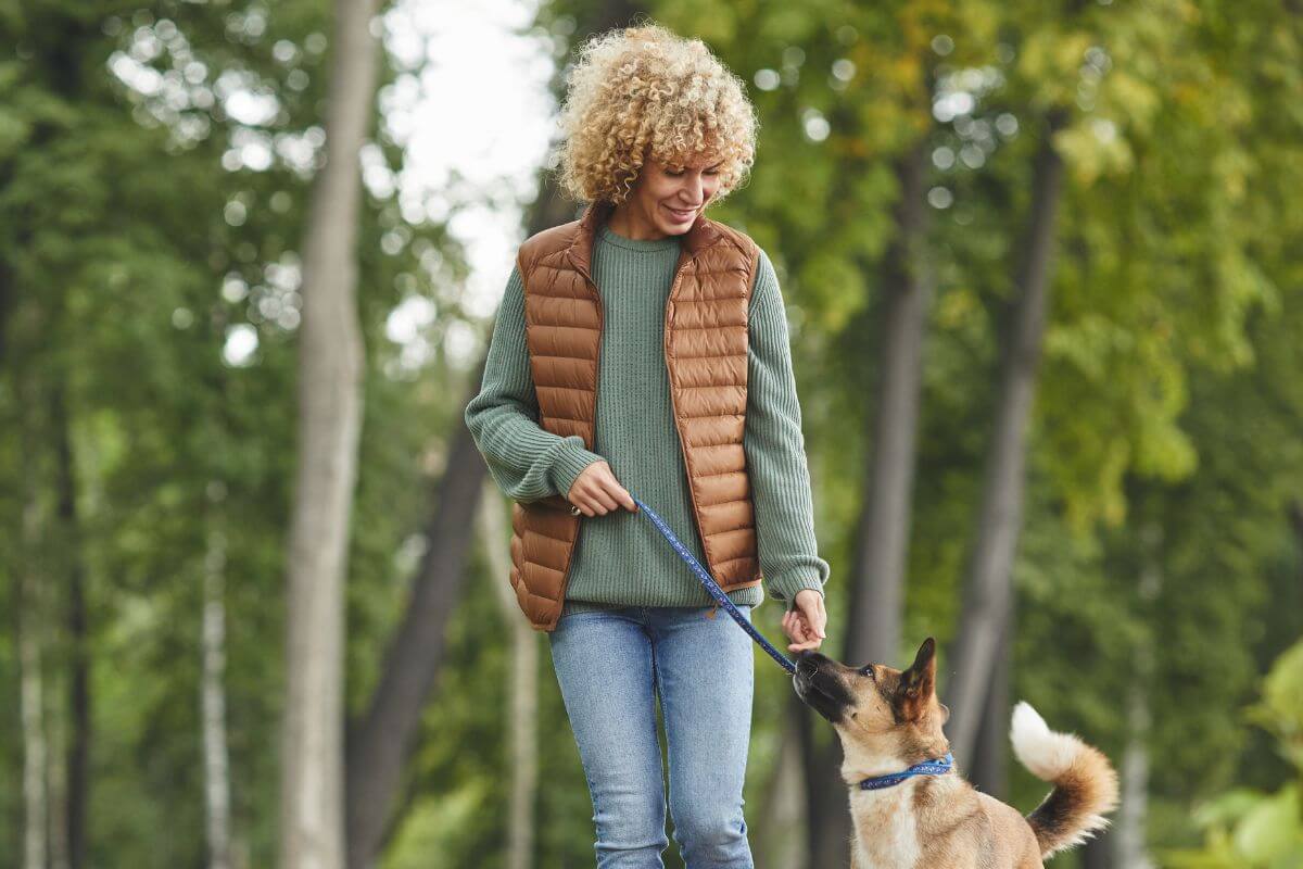 A picture of a woman walking their dog.