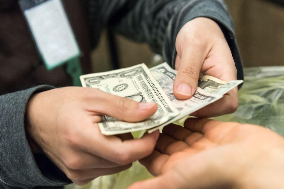 A picture of someone paying in cash.