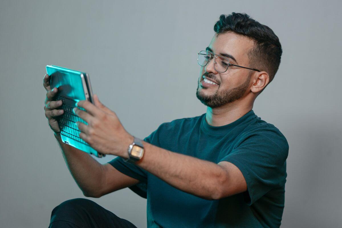 A picture of a man using their gadget.