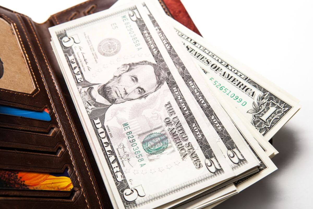 An image shows a wallet with dollar bills.