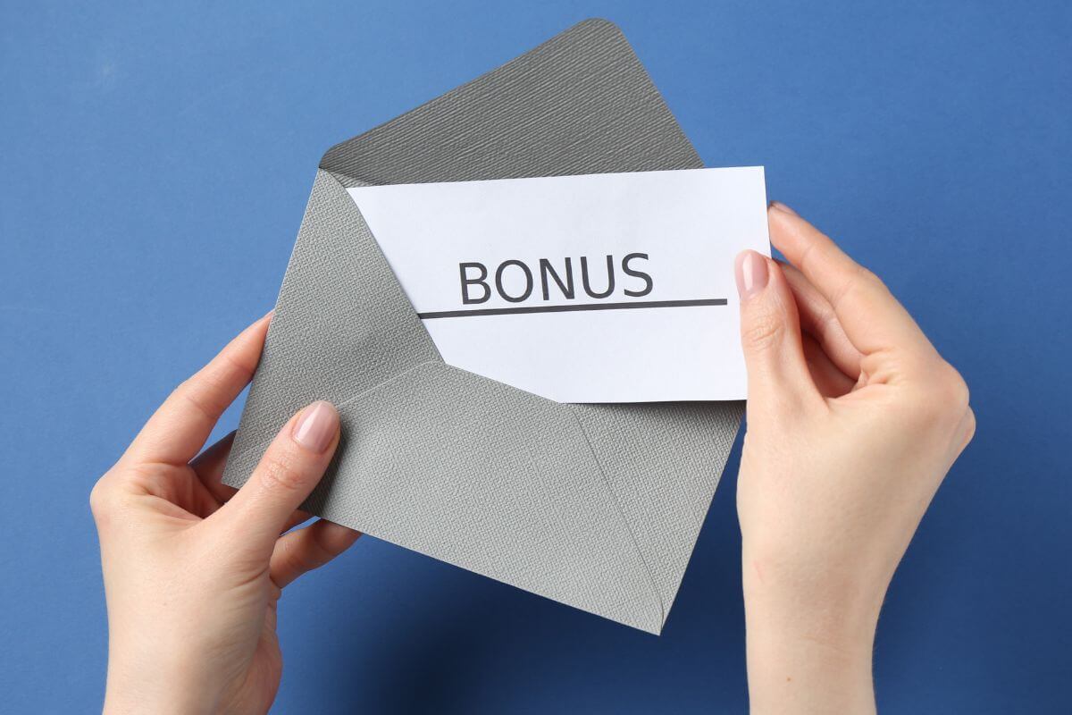 An image of a woman's hand holding an envelope.