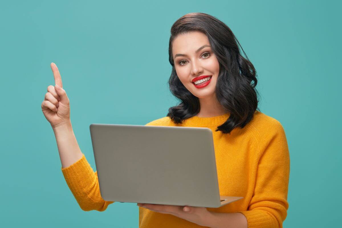 Une femme tenant un ordinateur portable.