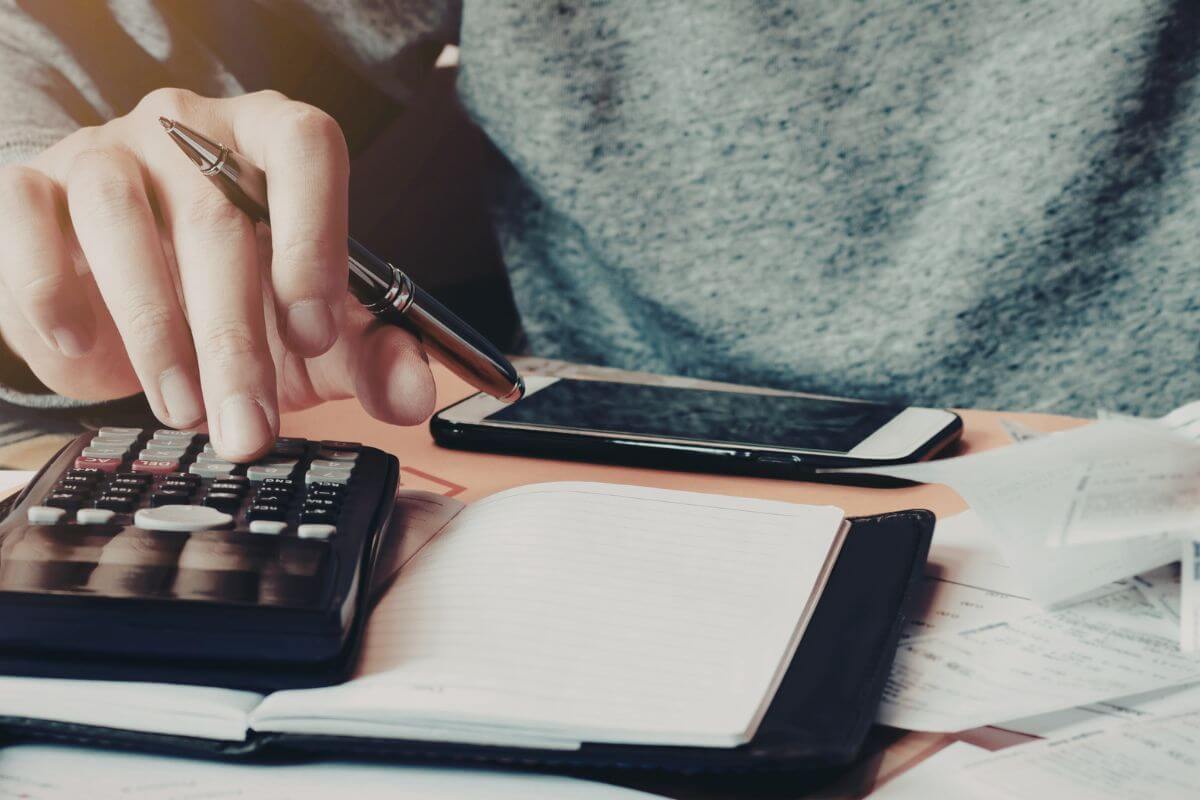 A picture shows a woman calculating her expenses.